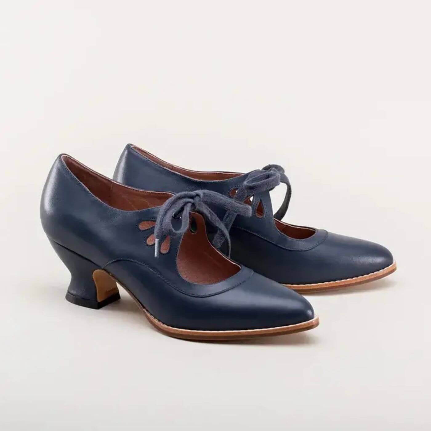 Elegante marineblaue Lederpumps mit vintage-inspirierten Cut-outs und Schnürsenkeln.