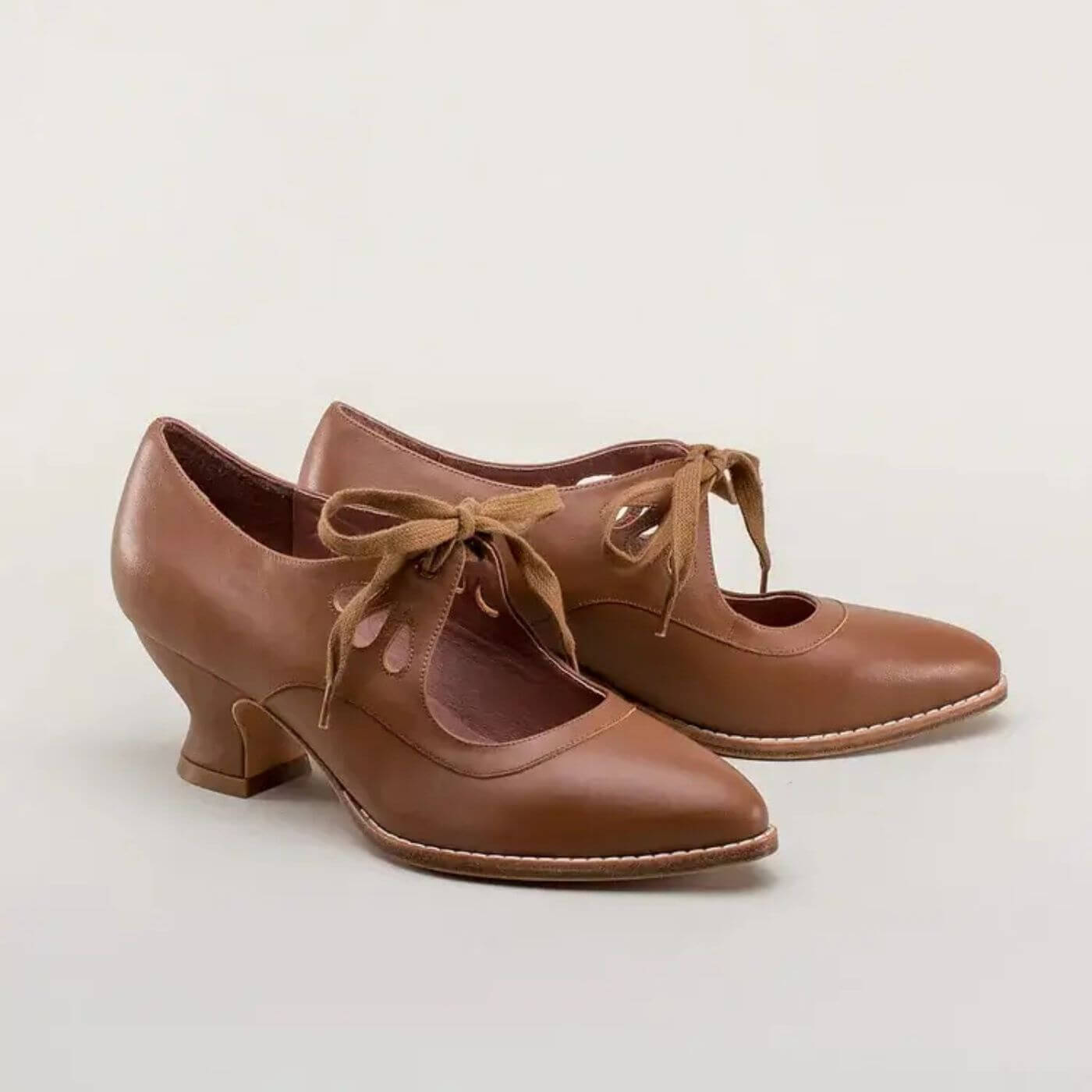 Zeitlose braune Lederpumps mit filigranen Cut-outs und bequemem Absatz.