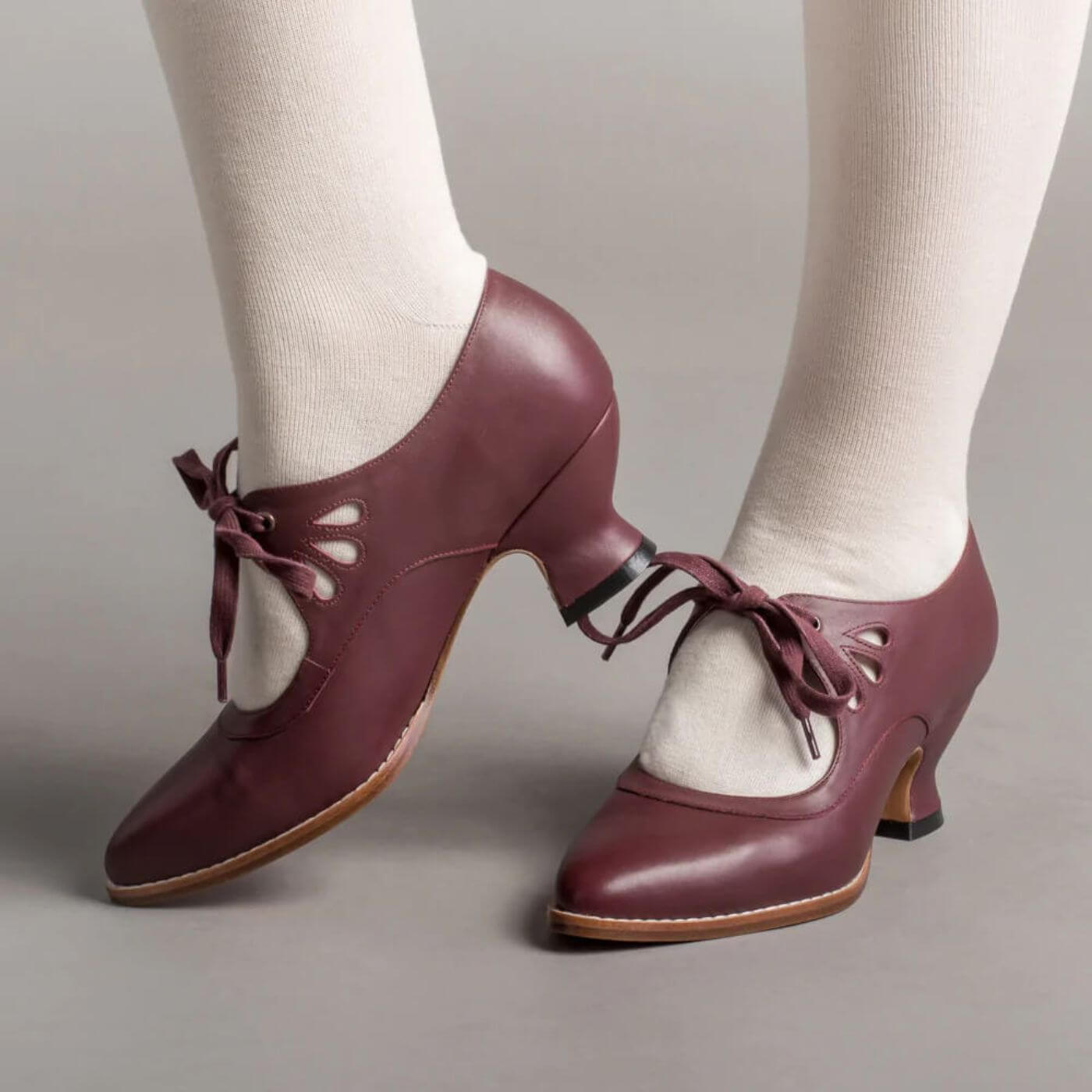 Retro-Stil karminrote Pumps mit weißen Strümpfen getragen, ideal für ein Vintage-Outfit.
