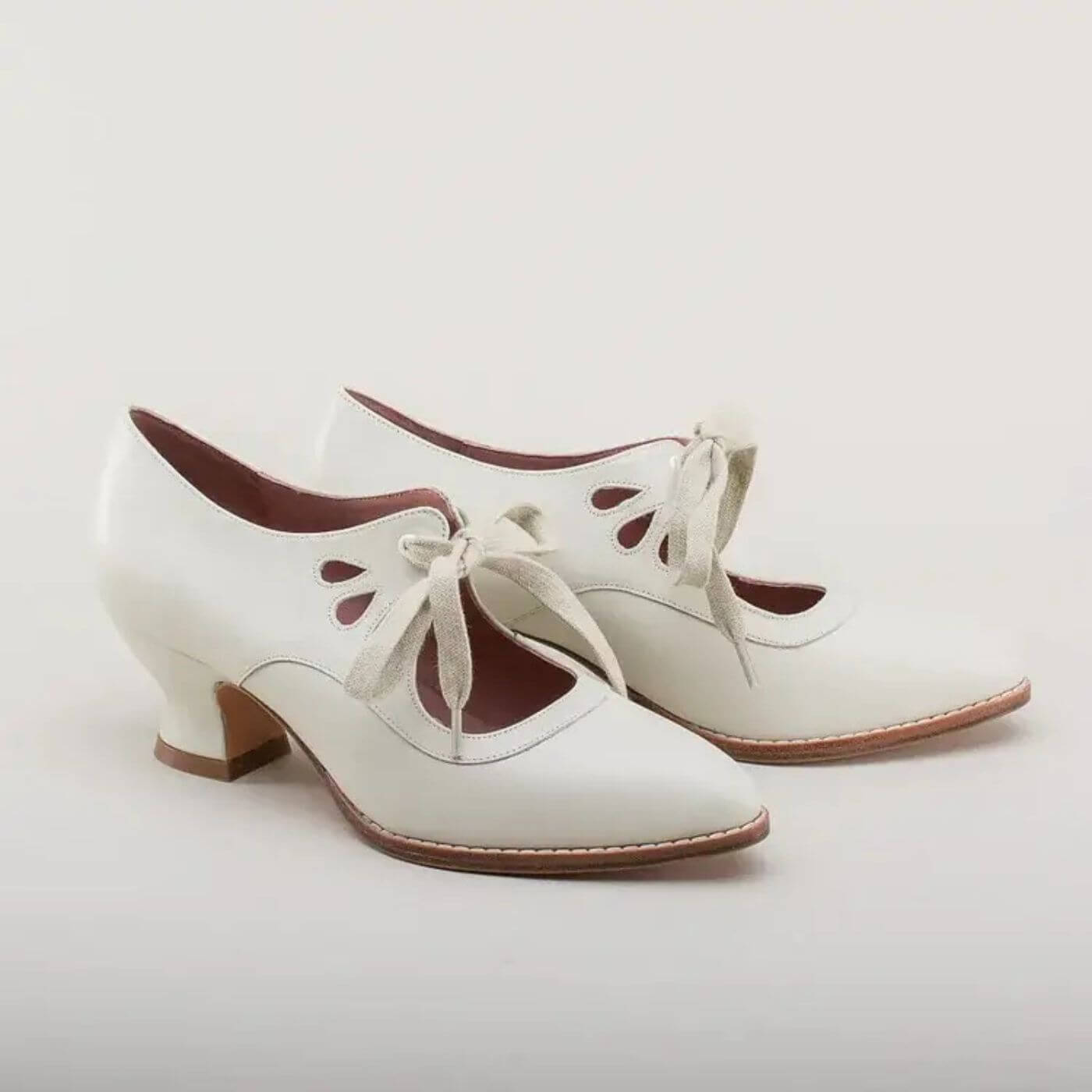 Vintage-weiße Lederschnürpumps mit eleganten Cut-outs für einen klassischen Look.