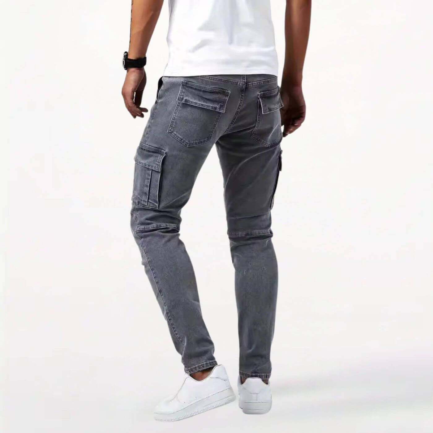 Rückansicht der grauen Slim-Fit-Cargo-Jeans für Herren mit mehreren Taschen und modernem, schmal zulaufendem Bein.
