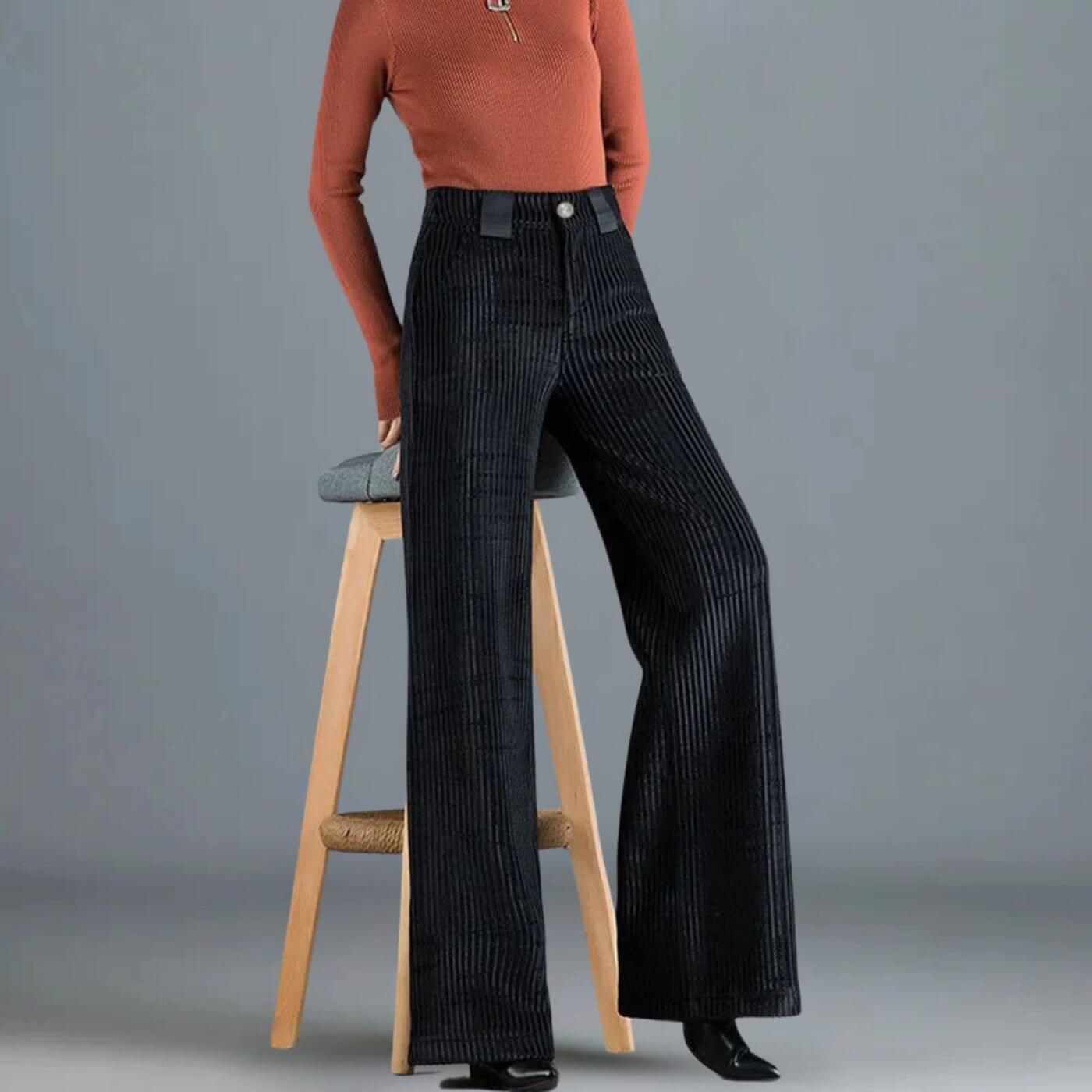 Femme portant un pantalon noir en velours côtelé avec un pull rouille.