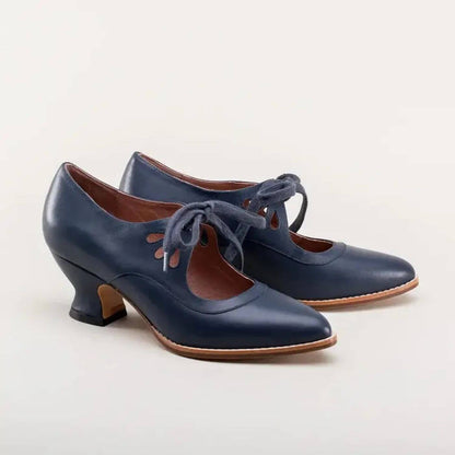 Elegante marineblaue Lederpumps mit vintage-inspirierten Cut-outs und Schnürsenkeln.